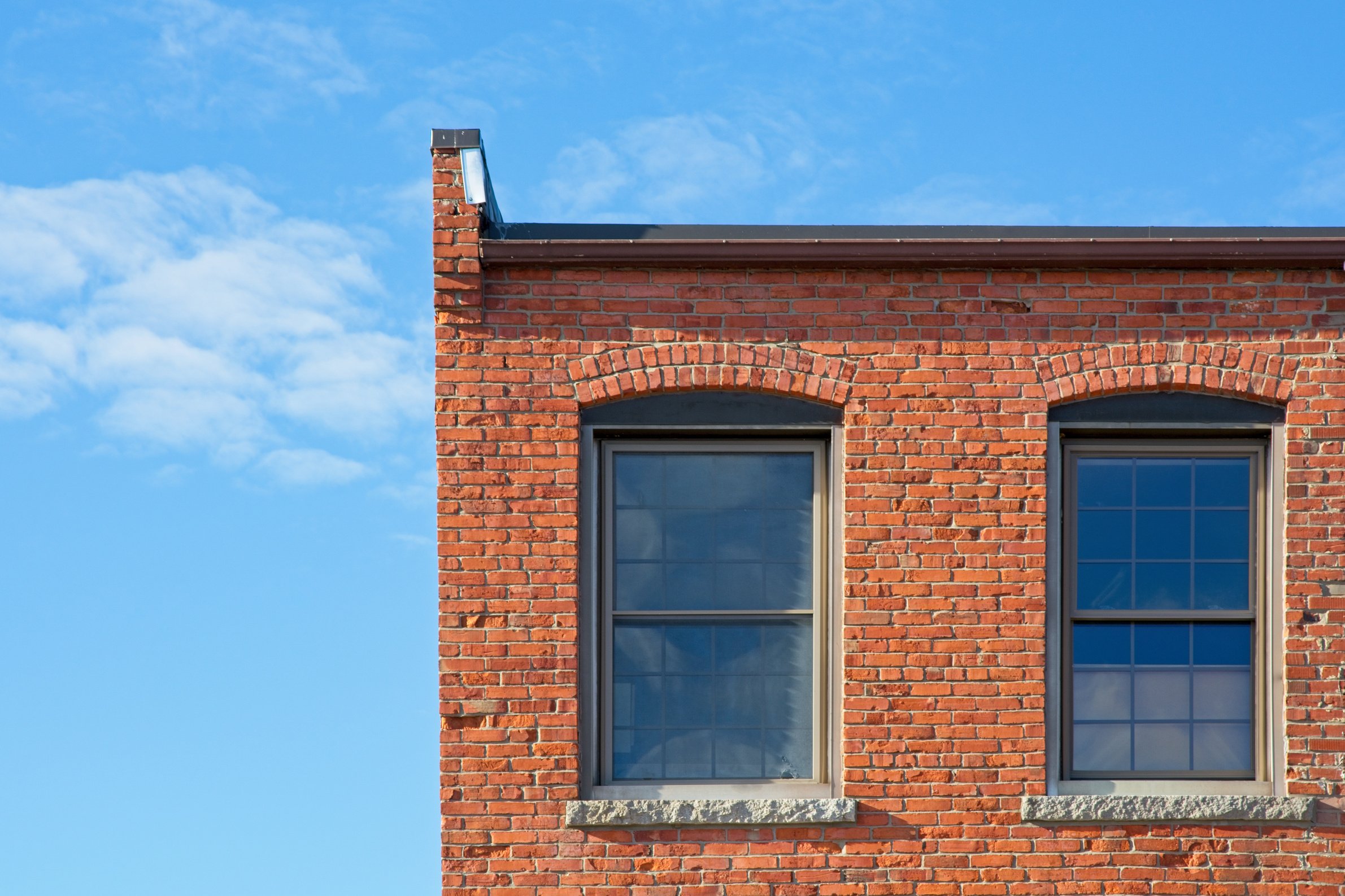 brick mill building roofline against bright blue sky in downtown Haverhill Massachusetts